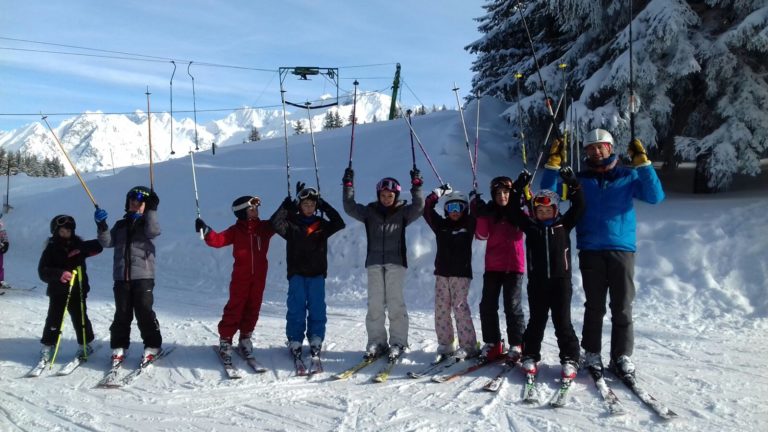 Photo de groupe de jeunes skieurs heureux sur le domaine alpin du ski club du Barioz